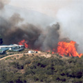 Image of wildfire threatening a house